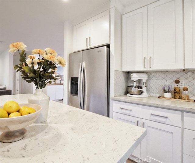 5435 W 76th St, Los Angeles, CA 90045 - kitchen with stainless steel fridge, tasteful backsplash, white cabinetry, and light stone countertops
