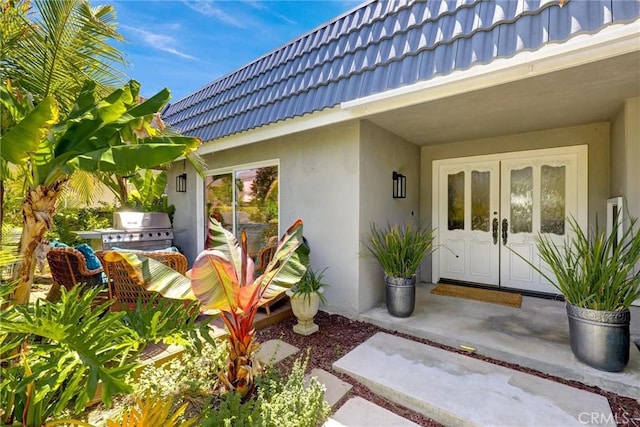 891 Palo Verde Ave, Long Beach, CA 90815 - view of exterior entry with stucco siding, a tile roof, french doors, and mansard roof