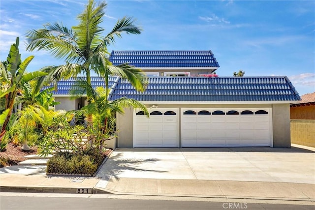891 Palo Verde Ave, Long Beach, CA 90815 - view of front facade featuring an attached garage, concrete driveway, stucco siding, and a tiled roof