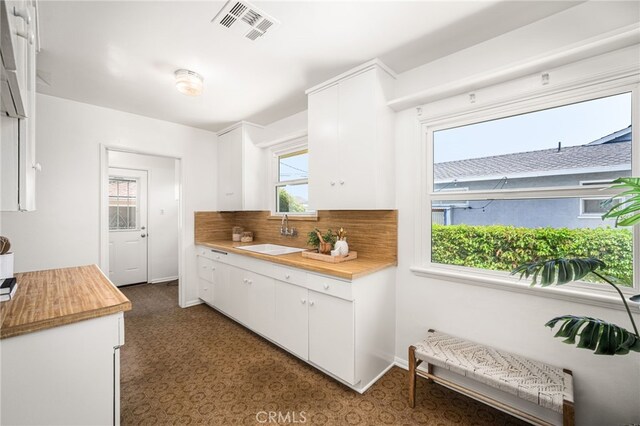 209 S Homerest Ave, West Covina, CA 91791 - kitchen featuring white cabinets, tasteful backsplash, wooden counters, and dark flooring