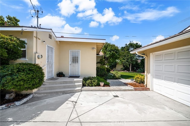 209 S Homerest Ave, West Covina, CA 91791 - view of exterior entry featuring stucco siding, a garage, and concrete driveway