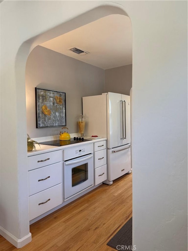 315 W 6th Ave, Chico, CA 95926 - kitchen with white appliances, light wood-style floors, white cabinets, and light countertops