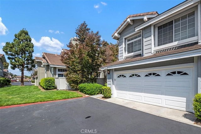 13562 Mahogany Pl, Tustin, CA 92782 - view of front facade featuring driveway, an attached garage, and a front yard