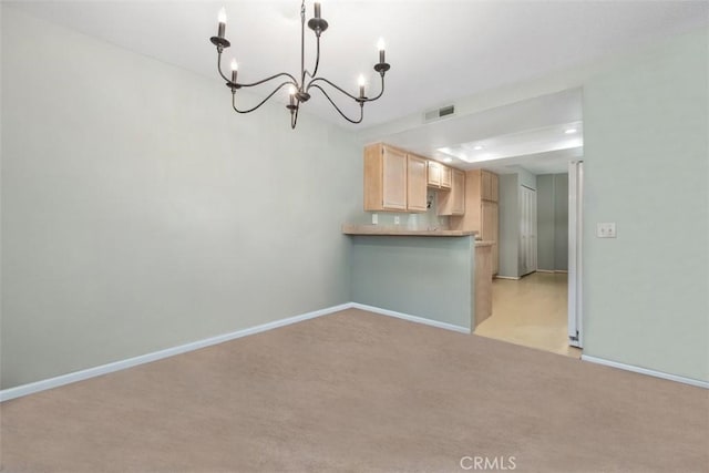 13562 Mahogany Pl, Tustin, CA 92782 - kitchen with a chandelier, light brown cabinets, light carpet, and a peninsula