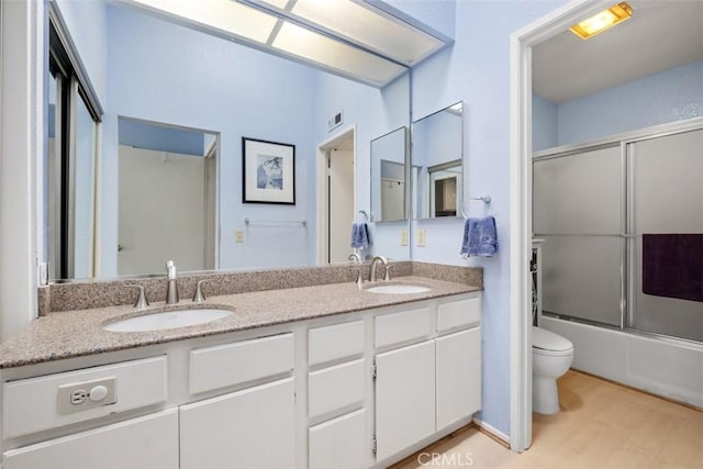 13562 Mahogany Pl, Tustin, CA 92782 - bathroom featuring double vanity, wood finished floors, and shower / bath combination with glass door