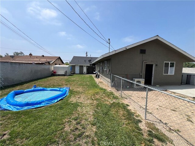 246 E 27th St, San Bernardino, CA 92404 - rear view of house featuring a pool and stucco siding