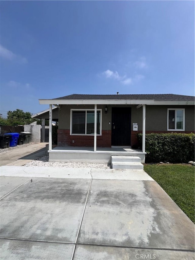 246 E 27th St, San Bernardino, CA 92404 - ranch-style home with brick siding, covered porch, and a shingled roof