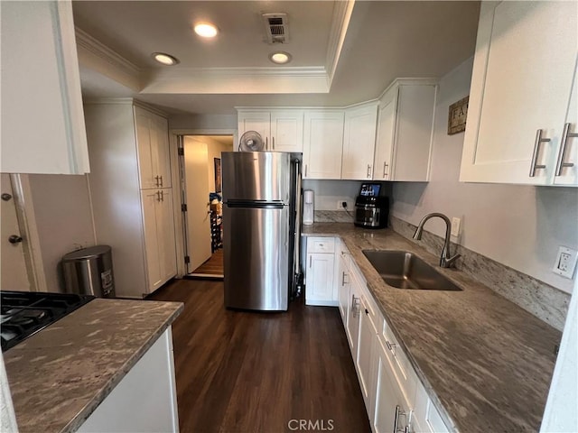 246 E 27th St, San Bernardino, CA 92404 - kitchen with freestanding refrigerator, a tray ceiling, crown molding, white cabinets, and dark stone countertops