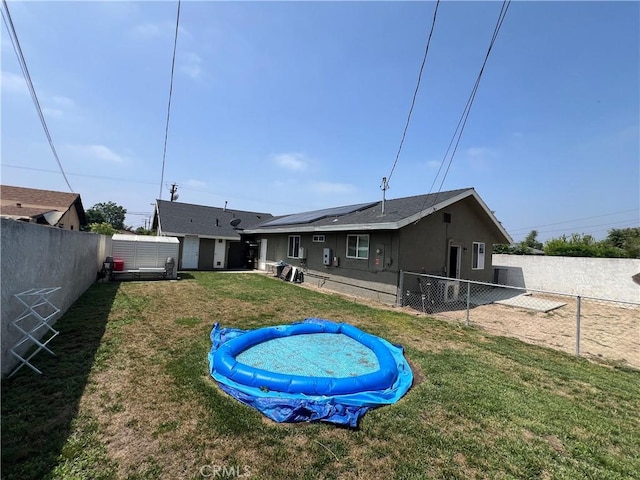 246 E 27th St, San Bernardino, CA 92404 - rear view of property with a fenced backyard, a shed, and solar panels