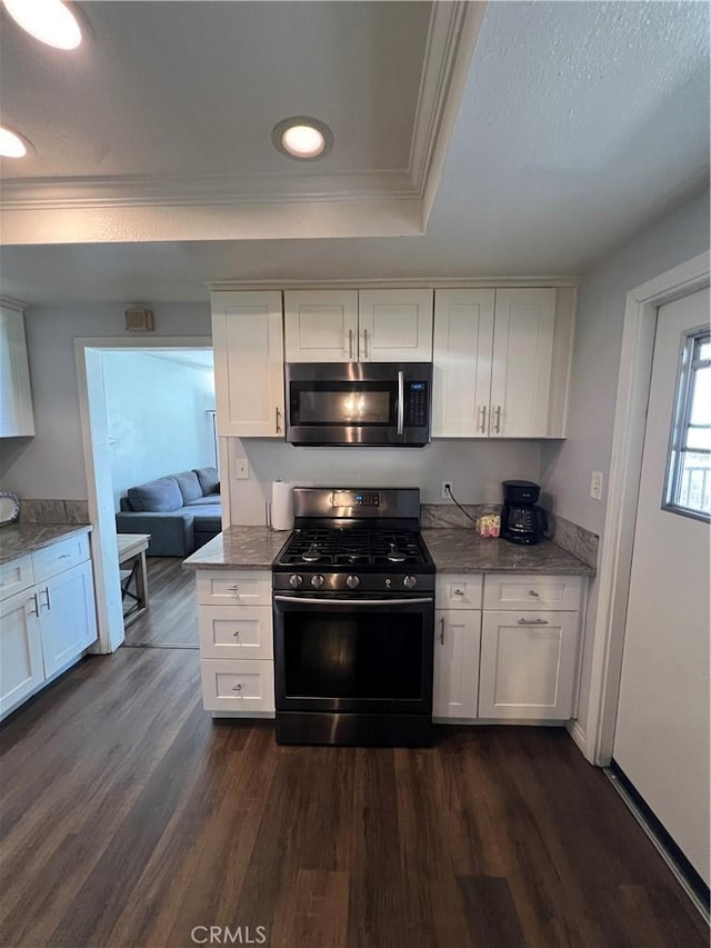 246 E 27th St, San Bernardino, CA 92404 - kitchen featuring black gas range, stainless steel microwave, ornamental molding, a tray ceiling, and white cabinetry