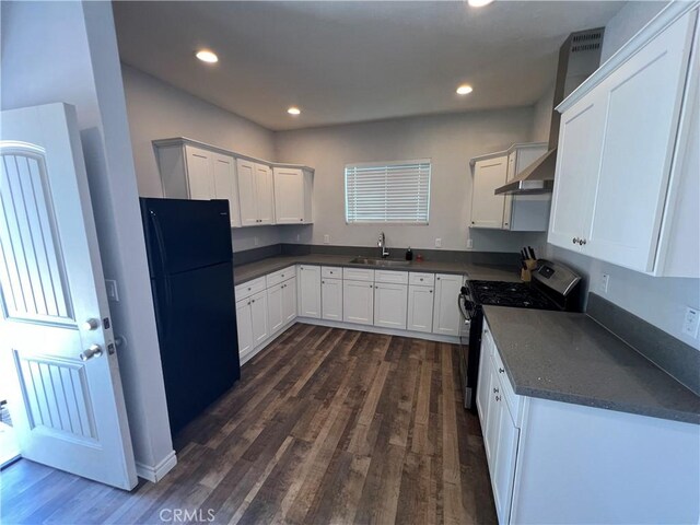 246 E 27th St, San Bernardino, CA 92404 - kitchen with gas range oven, freestanding refrigerator, ventilation hood, dark countertops, and dark wood-style flooring