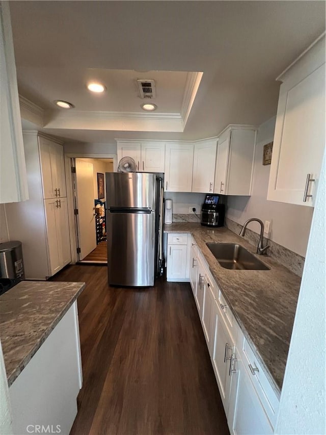 246 E 27th St, San Bernardino, CA 92404 - kitchen with freestanding refrigerator, a raised ceiling, white cabinetry, dark wood finished floors, and crown molding