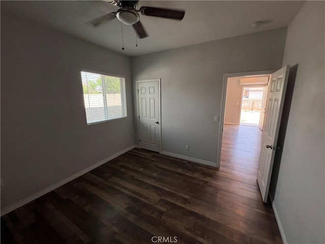 246 E 27th St, San Bernardino, CA 92404 - unfurnished bedroom with multiple windows, dark wood-style floors, and a ceiling fan