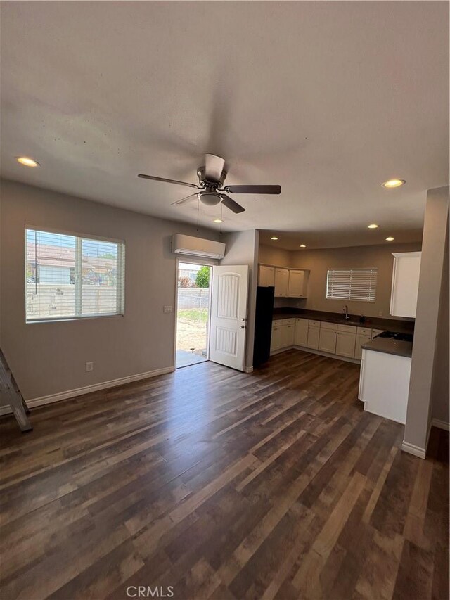 246 E 27th St, San Bernardino, CA 92404 - kitchen featuring dark countertops, white cabinetry, ceiling fan, a wall mounted AC, and recessed lighting