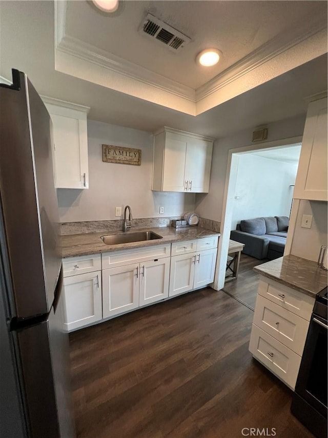 246 E 27th St, San Bernardino, CA 92404 - kitchen with freestanding refrigerator, a tray ceiling, ornamental molding, white cabinetry, and dark wood-style floors