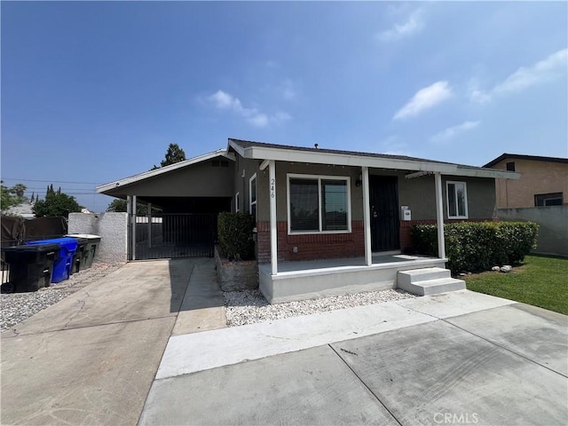 246 E 27th St, San Bernardino, CA 92404 - single story home with concrete driveway, an attached carport, brick siding, and covered porch
