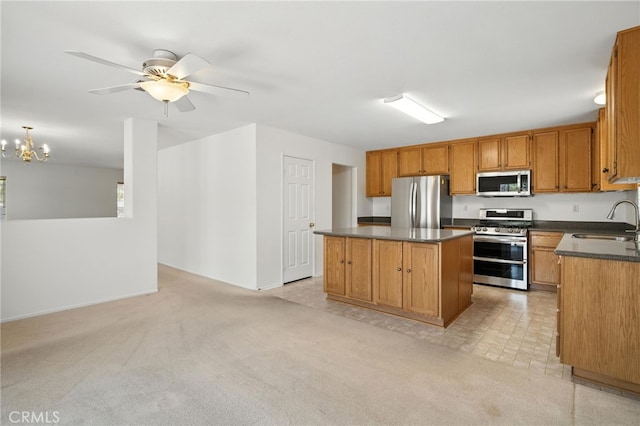39312 Via Belleza, Murrieta, CA 92563 - kitchen with appliances with stainless steel finishes, dark countertops, a center island, a chandelier, and brown cabinetry