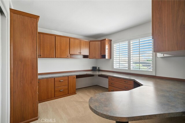39312 Via Belleza, Murrieta, CA 92563 - kitchen featuring built in desk, brown cabinetry, and a peninsula