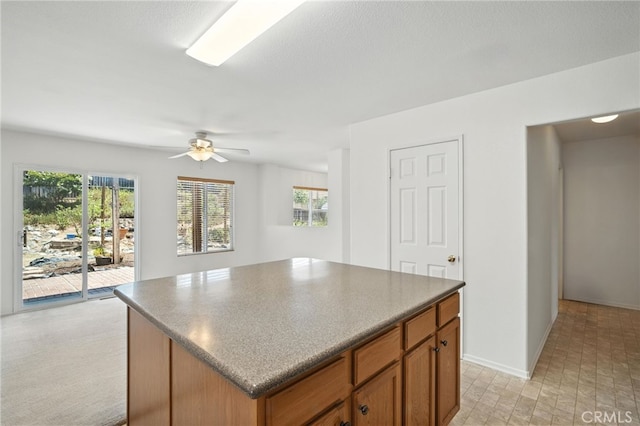 39312 Via Belleza, Murrieta, CA 92563 - kitchen with a kitchen island, brown cabinets, ceiling fan, and dark countertops