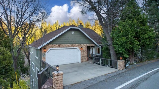 813 Brentwood Dr, Lake Arrowhead, CA 92352 - view of front of property with concrete driveway, an attached garage, roof with shingles, and stone siding
