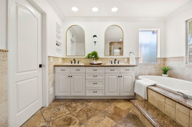 6407 Ruby, Carlsbad, CA 92011 - bathroom with tile walls, double vanity, ornamental molding, a garden tub, and stone tile flooring