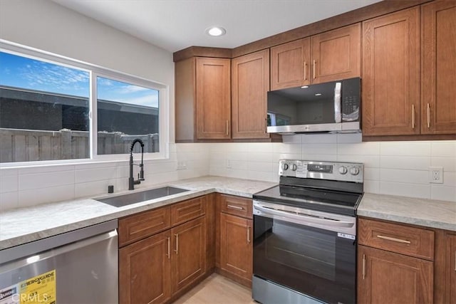 229 Springview, Irvine, CA 92620 - kitchen featuring stainless steel appliances, brown cabinetry, decorative backsplash, and recessed lighting