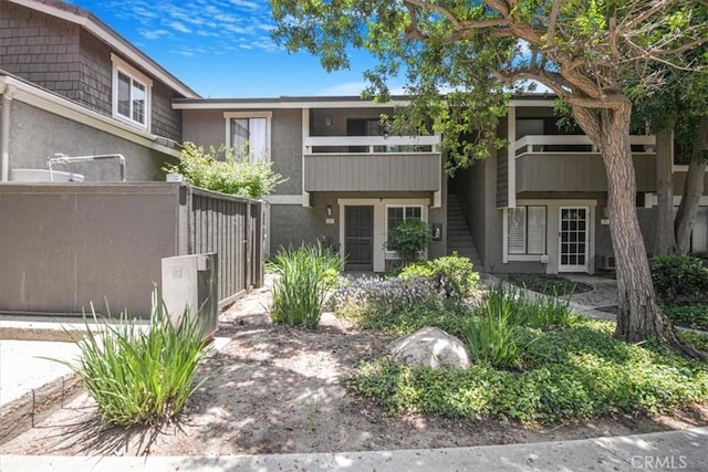 229 Springview, Irvine, CA 92620 - view of front of home featuring stucco siding, a balcony, and a gate