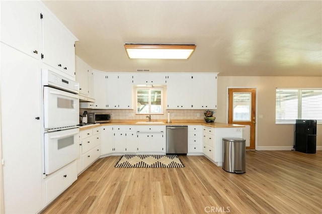 1019 W Monterey St, Orland, CA 95963 - kitchen featuring stainless steel appliances, light wood-style floors, backsplash, light countertops, and white cabinetry