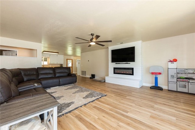 1019 W Monterey St, Orland, CA 95963 - living room featuring a ceiling fan, light wood-style floors, and a large fireplace