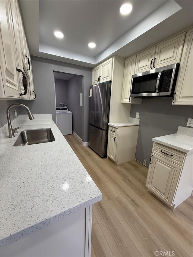 1804 Ewing Ct, Hacienda Heights, CA 91745 - kitchen featuring stainless steel appliances, washer / clothes dryer, a raised ceiling, light wood-style flooring, and light stone counters
