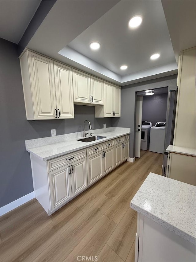 1804 Ewing Ct, Hacienda Heights, CA 91745 - kitchen featuring separate washer and dryer, a tray ceiling, light wood finished floors, recessed lighting, and light stone countertops