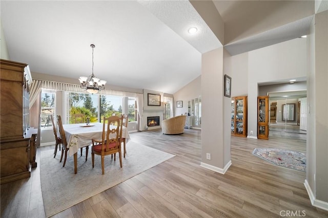 11056 Orchard View Ln, Riverside, CA 92503 - dining room with a warm lit fireplace, light wood-type flooring, high vaulted ceiling, a chandelier, and recessed lighting
