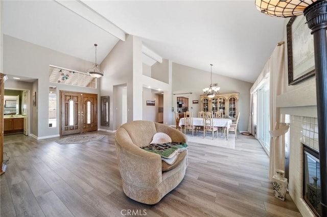 11056 Orchard View Ln, Riverside, CA 92503 - living room featuring wood finished floors, beamed ceiling, high vaulted ceiling, a tile fireplace, and a chandelier