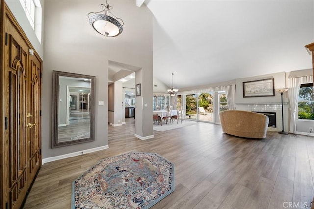 11056 Orchard View Ln, Riverside, CA 92503 - entrance foyer with a chandelier, wood finished floors, high vaulted ceiling, and a tile fireplace