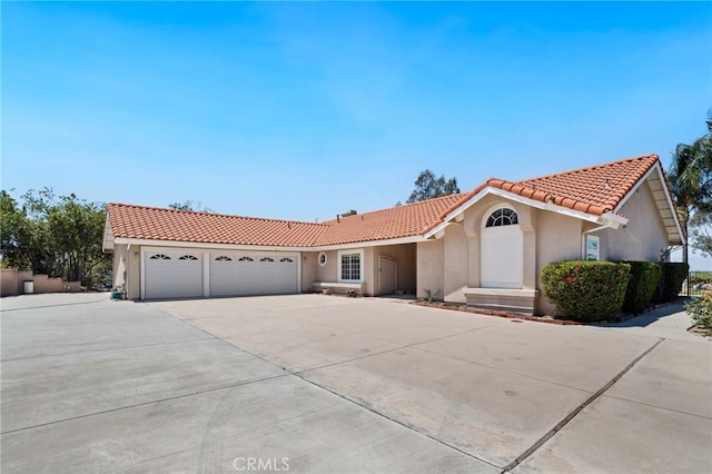 11056 Orchard View Ln, Riverside, CA 92503 - view of front of home with a tile roof, stucco siding, an attached garage, and driveway