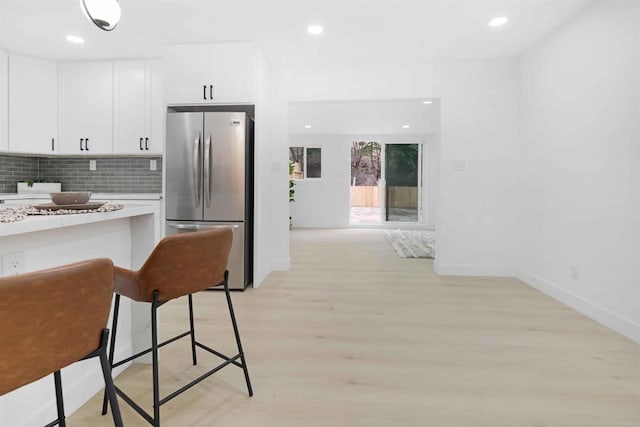 254 Rexview Dr, San Diego, CA 92114 - kitchen with freestanding refrigerator, light countertops, white cabinets, tasteful backsplash, and light wood finished floors