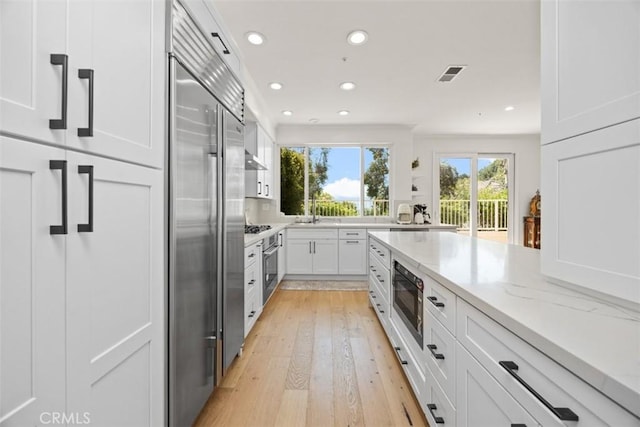 1872 Caminito De La Narcissa, Glendale, CA 91208 - kitchen with built in appliances, light stone counters, recessed lighting, white cabinets, and light wood-type flooring