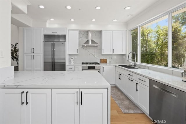 1872 Caminito De La Narcissa, Glendale, CA 91208 - kitchen with appliances with stainless steel finishes, wall chimney range hood, white cabinets, light stone counters, and decorative backsplash