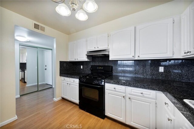 981 S St Andrews Pl Unit 104, Los Angeles, CA 90019 - kitchen featuring black range with gas stovetop, under cabinet range hood, white cabinets, backsplash, and light wood-type flooring