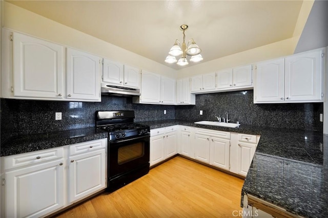 981 S St Andrews Pl Unit 104, Los Angeles, CA 90019 - kitchen with black gas range, under cabinet range hood, white cabinets, a chandelier, and tasteful backsplash