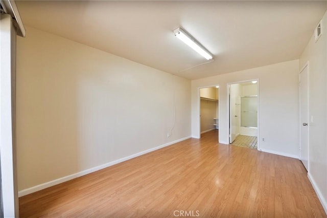 981 S St Andrews Pl Unit 104, Los Angeles, CA 90019 - unfurnished bedroom with light wood-style floors, a spacious closet, a closet, and ensuite bathroom