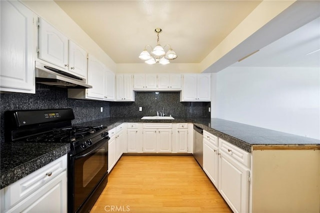 981 S St Andrews Pl Unit 104, Los Angeles, CA 90019 - kitchen with black gas range oven, under cabinet range hood, a peninsula, a chandelier, and white cabinets