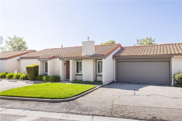 19533 Rinaldi St Unit 48, Porter Ranch, CA 91326 - mediterranean / spanish home with a chimney, stucco siding, a tile roof, an attached garage, and a front lawn