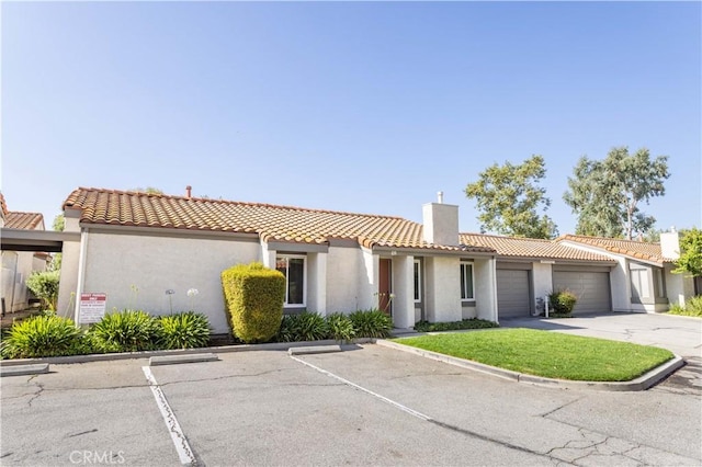 19533 Rinaldi St Unit 48, Porter Ranch, CA 91326 - view of front of house with stucco siding, a chimney, a tiled roof, and uncovered parking