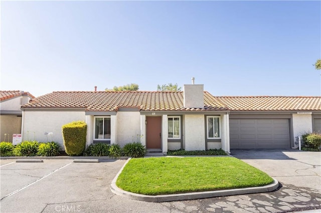 19533 Rinaldi St Unit 48, Porter Ranch, CA 91326 - view of front of home featuring a chimney, stucco siding, a tiled roof, and a front lawn