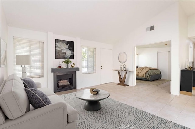 19533 Rinaldi St Unit 48, Porter Ranch, CA 91326 - living area featuring a glass covered fireplace, lofted ceiling, and light tile patterned flooring