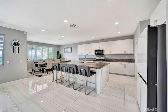 18348 Cachet Way, Canyon Country, CA 91350 - kitchen featuring stainless steel appliances, a breakfast bar area, white cabinetry, a kitchen island with sink, and recessed lighting