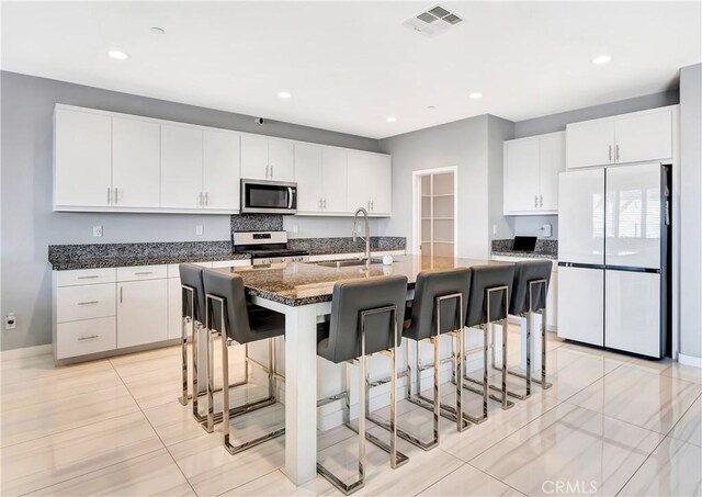 18348 Cachet Way, Canyon Country, CA 91350 - kitchen featuring freestanding refrigerator, stainless steel microwave, electric stove, a breakfast bar area, and recessed lighting