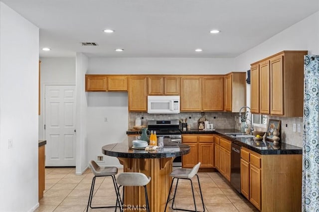 35733 Emily Ave, Murrieta, CA 92563 - kitchen featuring white microwave, light tile patterned floors, tasteful backsplash, a breakfast bar area, and recessed lighting