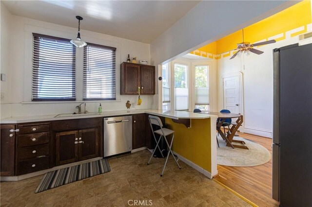 320 W 21st St, Merced, CA 95340 - kitchen with stainless steel appliances, a peninsula, dark brown cabinetry, and light countertops